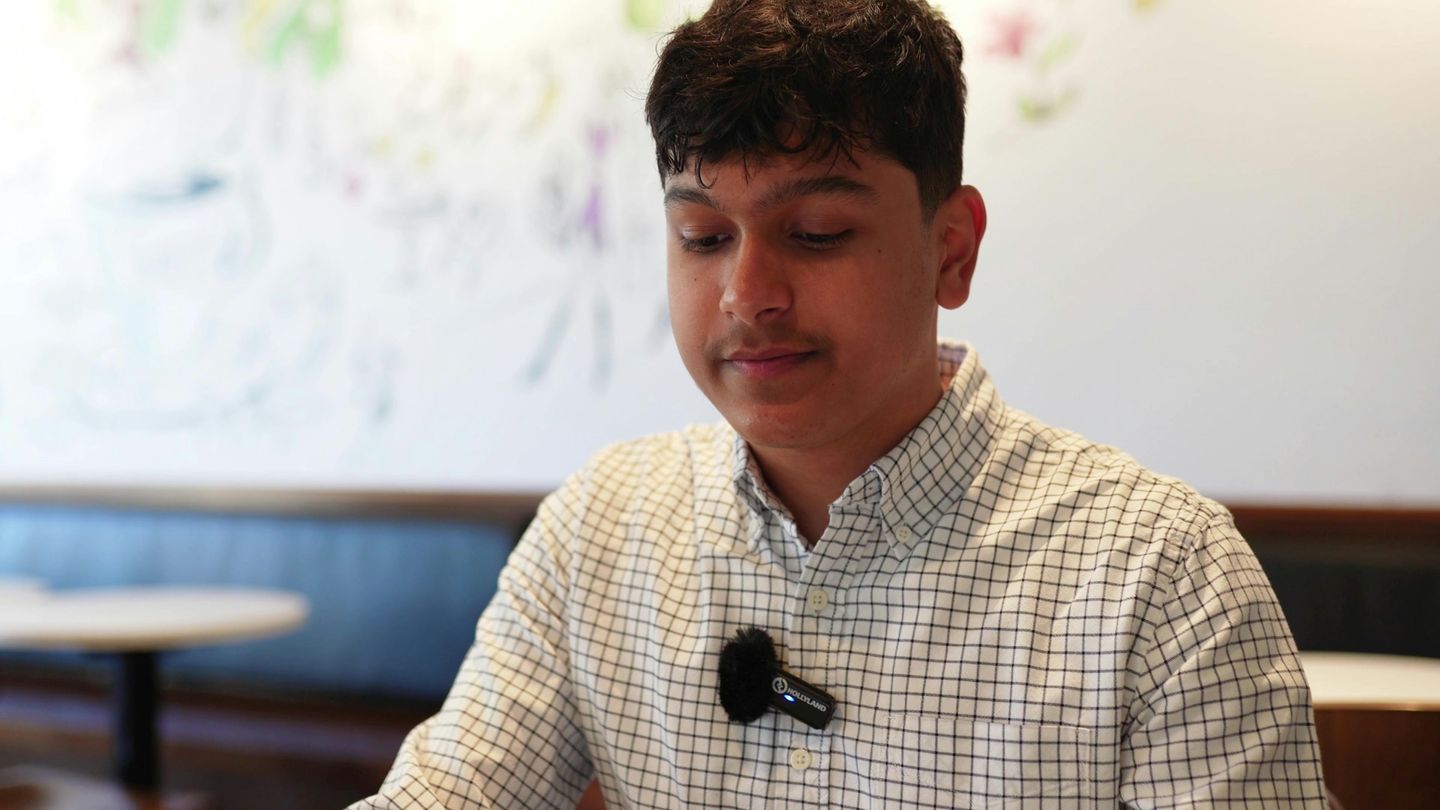 A young man wearing a small clip-on microphone on his shirt