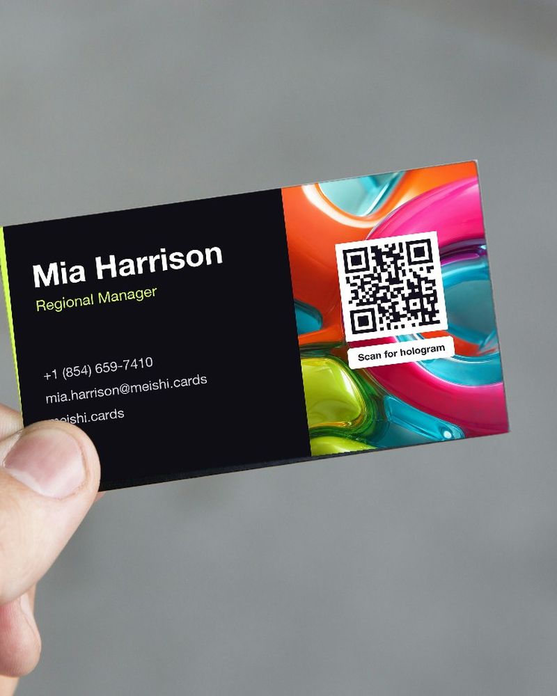 A hand holding a business card with a QR code